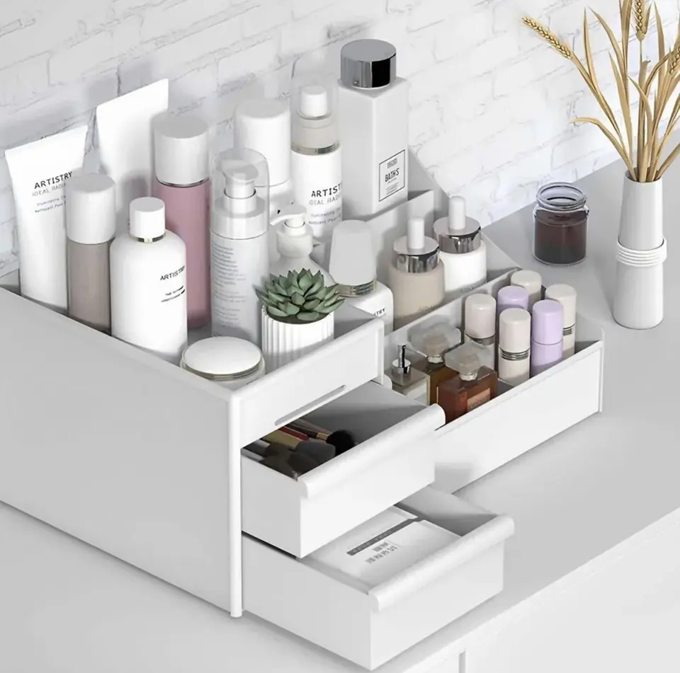 Organizador de maquillaje de plástico con múltiples compartimentos superiores y cajones deslizantes