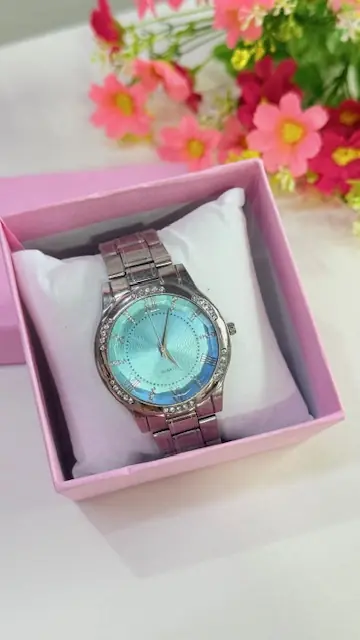 Reloj plateado con fondo celeste y detalles en strass