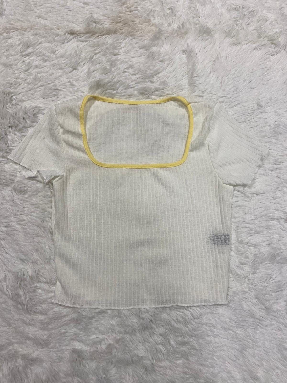 Remera canale blanca cuello amarillo pastel